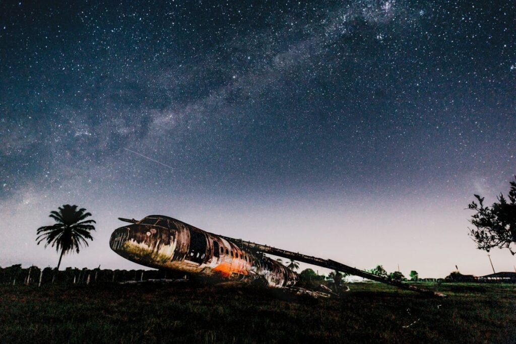 Crashed airplane on land under bright sky in evening