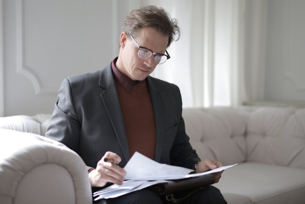 Man with eyeglass reading the paper about injury client