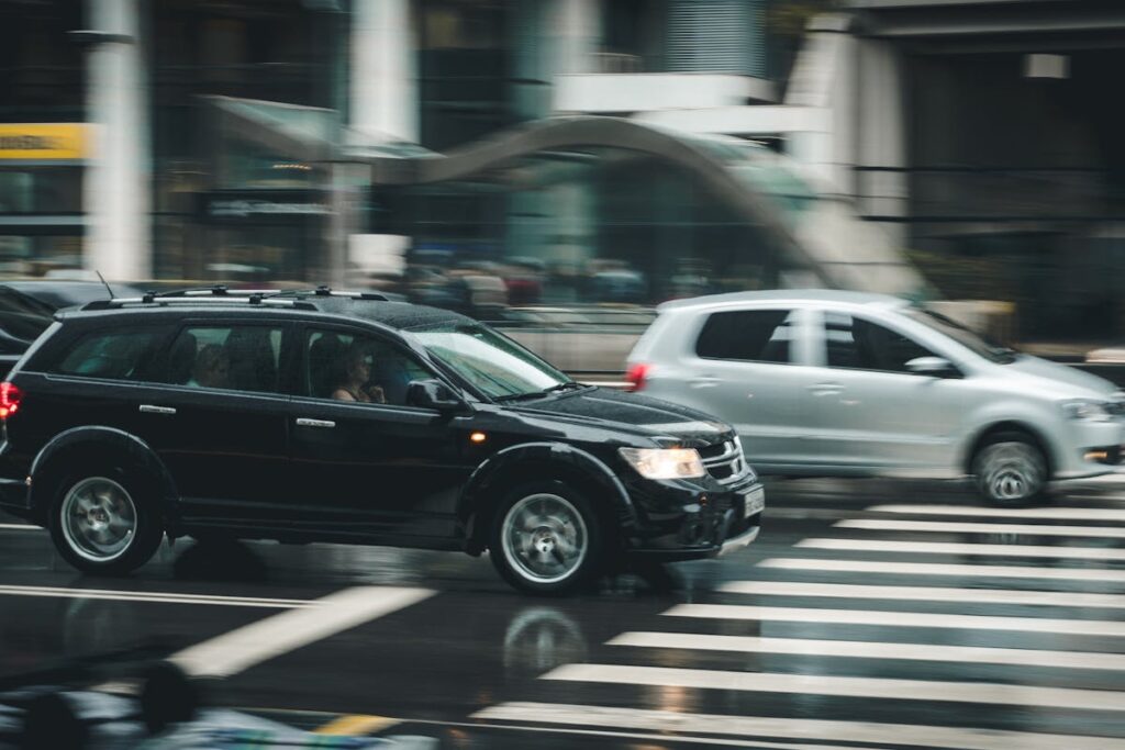 Black Suv Beside Grey Auv Crossing the Pedestrian Line during Daytime