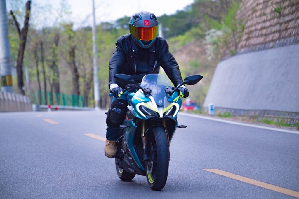 A Person in Black Leather Jacket Riding a Motorcycle