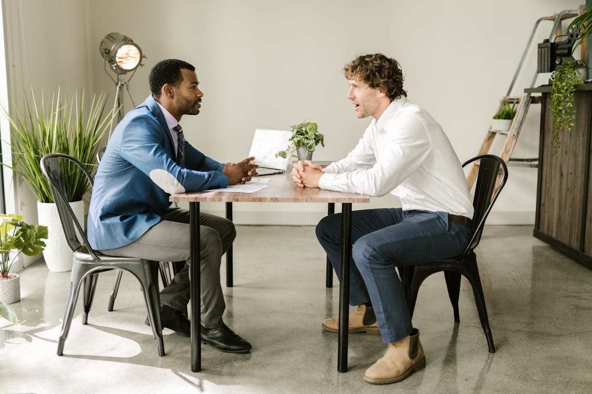 Two Men Sitting at Table Talking